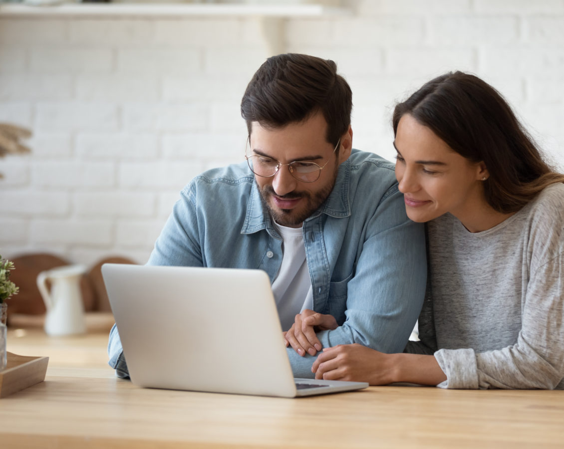 Happy young mixed race married spouse making purchases online.